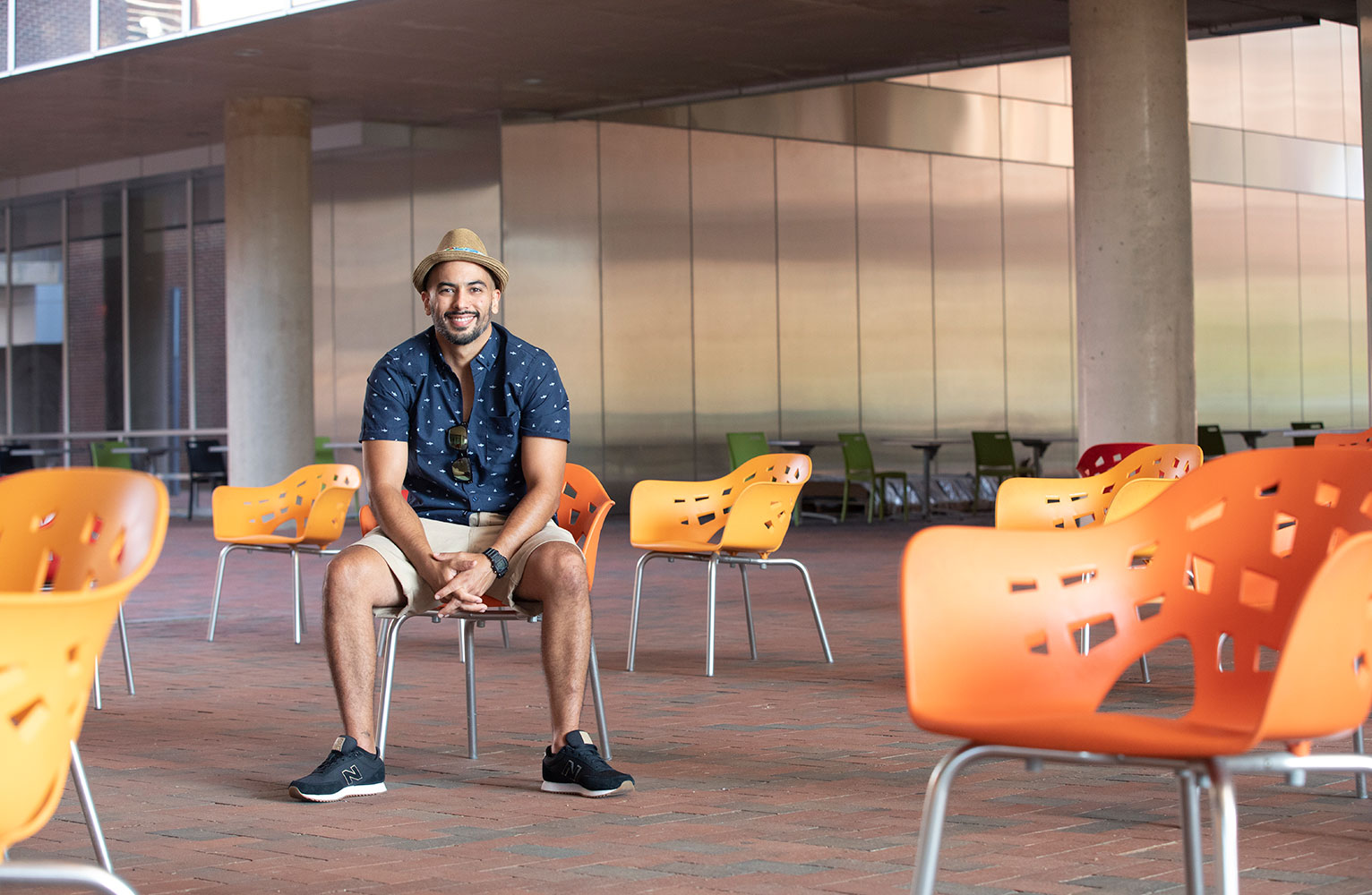 Esteban Agudo sits in a chair in a courtyard