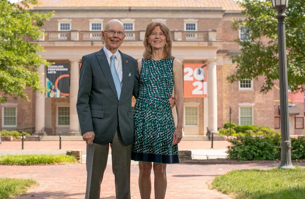 James and Susan Moeser pose outdoors in front of South Building on UNC-Chapel Hill's campus.