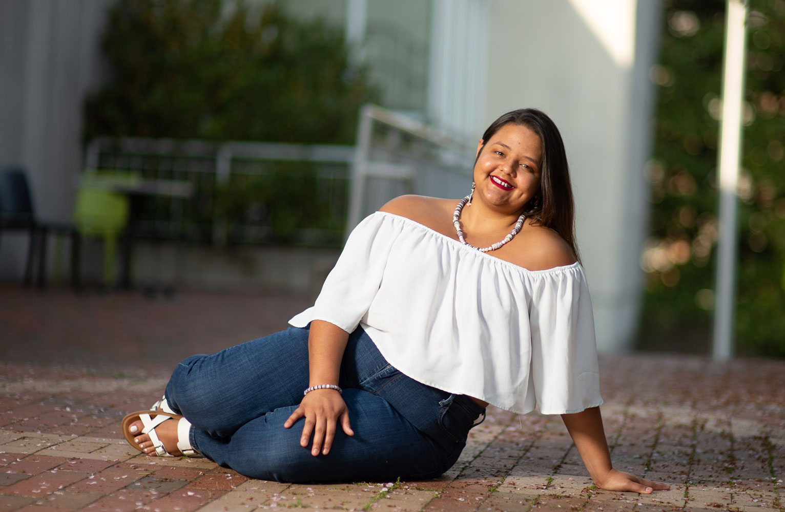 Mikayah Locklear poses sitting on the ground outside