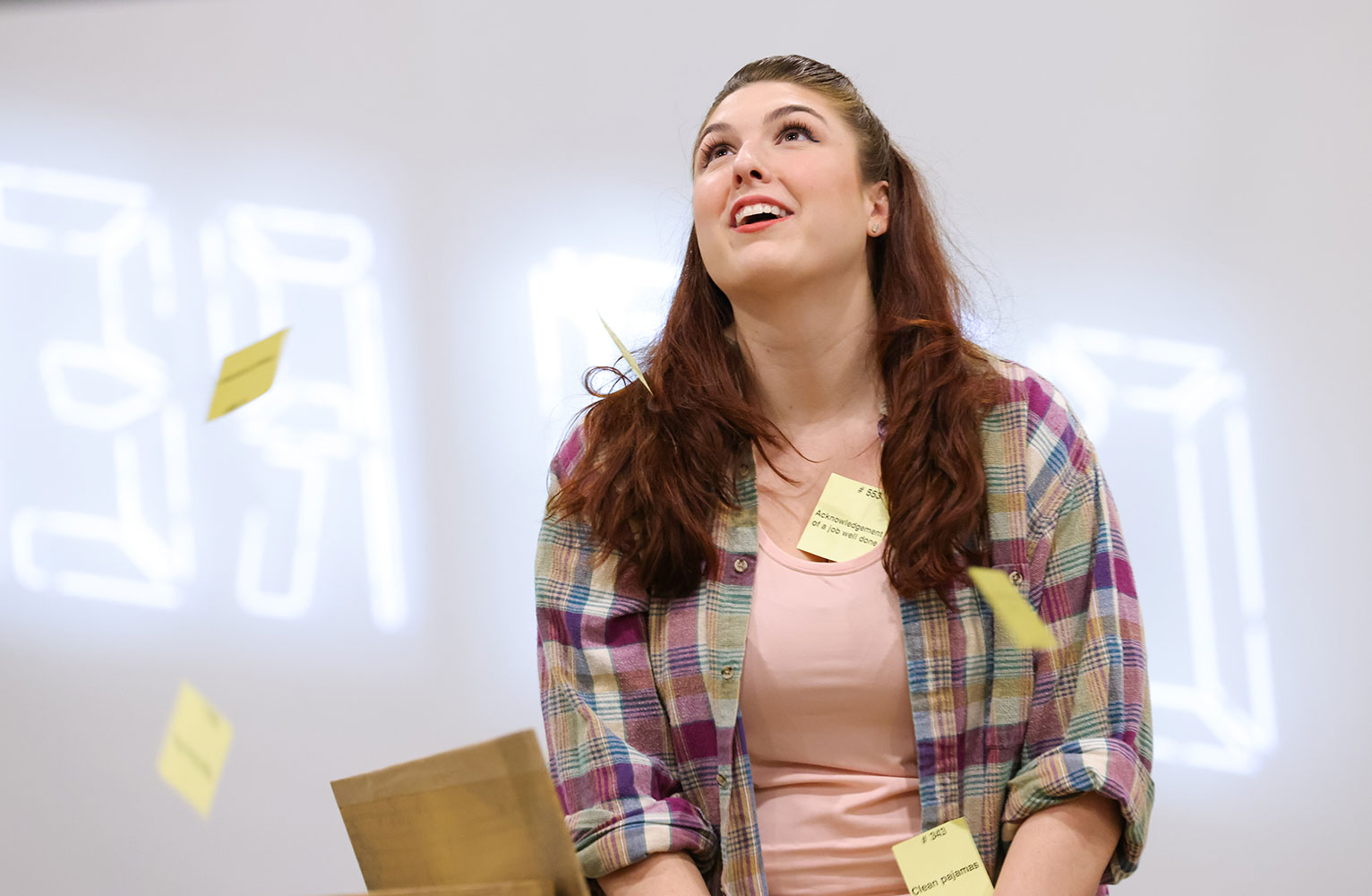 Hayley Cartee throws sticky notes in the air during a performance of Every Brilliant Thing.